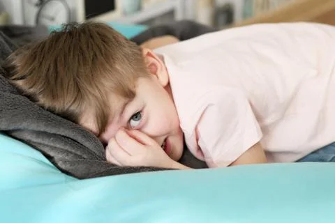 A boy plays hide-and-seek at home on the couch. Stock Photos