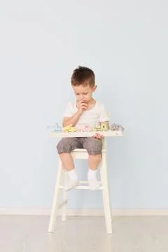 A boy plays with a machine and sits on the chair Stock Photos