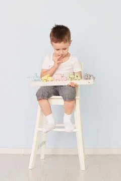 A boy plays with a machine and sits on the chair Stock Photos