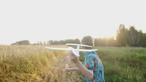 A boy plays with a model airplane during sunset. Dream to be a pilot Stock Footage 82203864