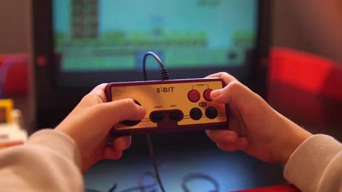 Boy plays old vintage eight-bit 8 bit video console, pressing joystick buttons Stock Footage 270103425