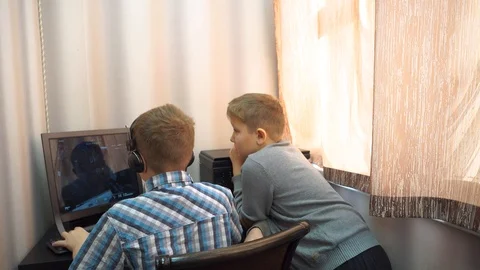 The boy plays an online game on the computer through an Internet monitor with he Stock Footage 99222884