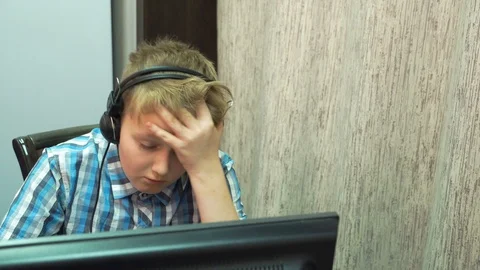 The boy plays an online game on a computer through an Internet monitor with head Stock Footage 99223791