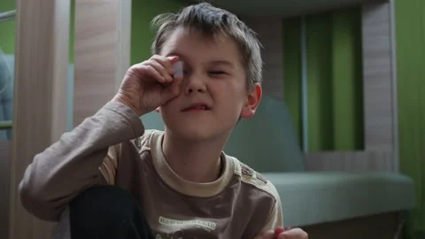 The boy plays with plastic mirrors from the designer holding them up to his eyes Stock Footage 146794104
