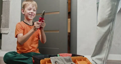 Boy plays with pliers repeatedly opening and closing jaws Stock Footage 323969085