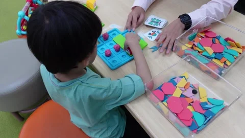 The boy plays puzzle happily, showing a happy and satisfied expression. Stock Footage 297732106