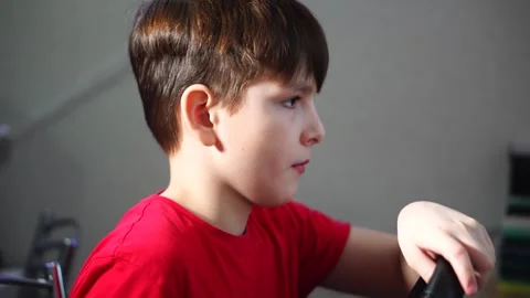 Boy plays racing simulator on computer steering wheel. Stock Footage 297450984