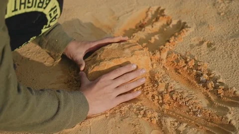 Boy plays with sand at sunset of the day. Beautiful evening frames Stock Footage 140417405