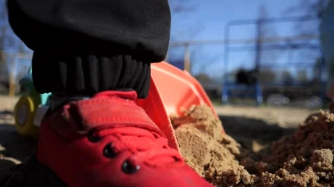 A boy plays in the sandbox with a tractor and a truck, loads them with sand usin Stock Footage 273281154