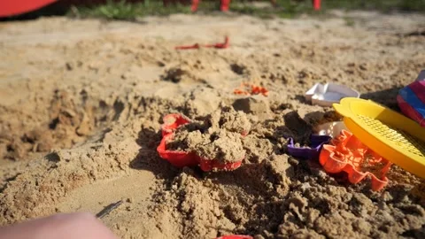 A boy plays in the sandbox with a tractor and a truck, loads them with sand usin Stock Footage 273281206