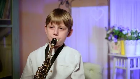 The boy plays the saxophone Vídeos de archivo 73390108