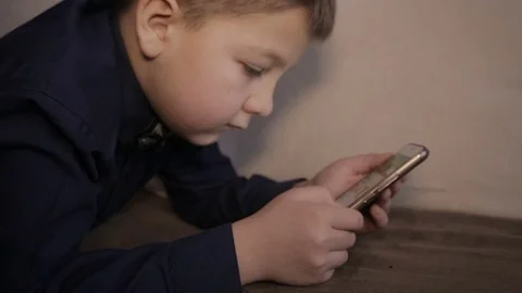 A boy plays on the smartphone Stock Footage 71944188