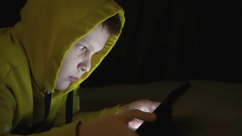 The boy plays on the tablet in the bedroom in complete darkness. Stock Footage 234526421