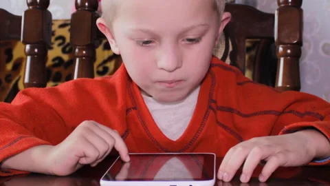A boy plays on a tablet 스톡 동영상 310090830