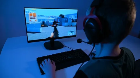 Boy plays violent online video game on pc and shoots with a gun Stock Footage 100792850