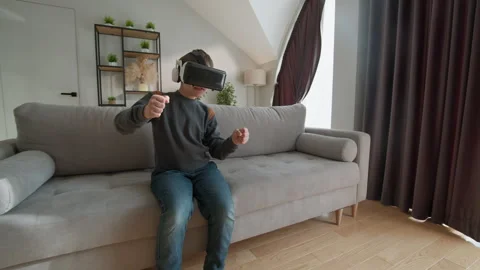 Boy Plays Virtual Reality Game. Immersive child headset digital fun modern home Stock Footage 335481736