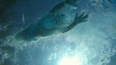 Boy plunging in water, shot from below. Slow motion shot at 100 fps Stock Footage 112663585