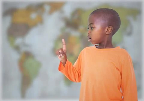 Boy pointing against blurry map Stock Photos