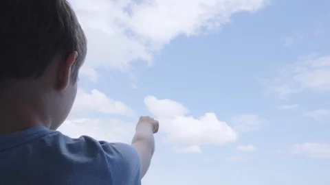 Boy pointing hand to blue sky and draw with finger clouds Stock Footage 128571610
