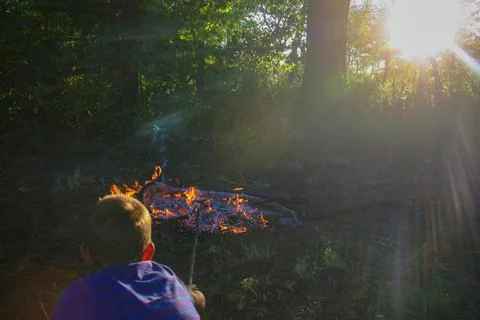 Boy pokes in fire Foto stock