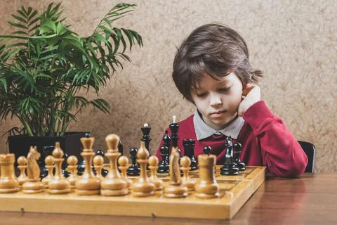 Boy pondering on next move playing chess Stock Photos