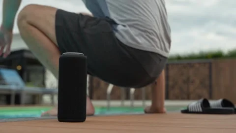 Boy at the pool chilling with music from his Bluetooth speaker at his side. Stock Footage 255923822