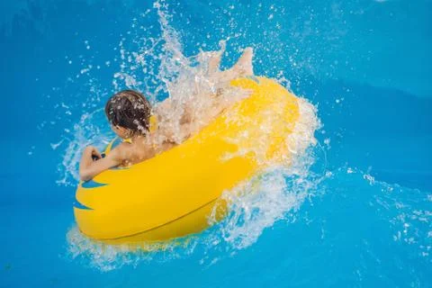 Boy on a pool float on artificial waves in a water park Stock Photos