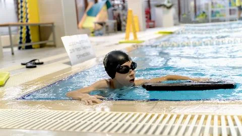 Boy in the pool learning to swim Stock Photos
