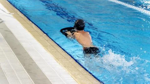 Boy in the pool learning to swim with a trainer 스톡 사진
