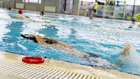Boy in the pool learning to swim with a trainer Stock Photos