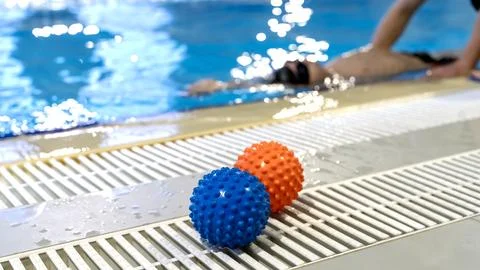 Boy in the pool learning to swim with a trainer Stock-Fotos