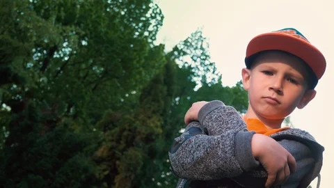 Boy posing on camera standing against the background of trees, crossing his arms Stock Footage 89141769