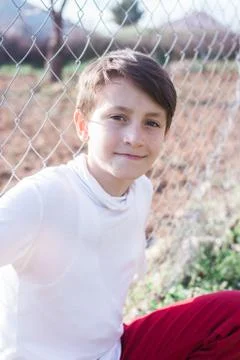 Boy posing by a fence Stock Photos