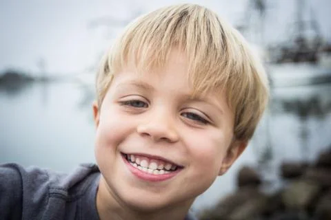 Boy posing on the rocks at the harbor Stock Photos
