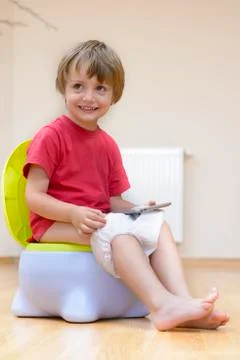 Boy on potty using tablet pc Stock Photos