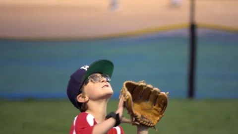A boy practices playing catch on a little league baseball field, super slow moti Stock Footage 70466063