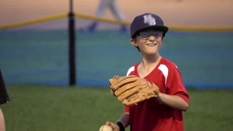 A boy practices playing catch on a little league baseball field, super slow moti Stock Footage 70466067