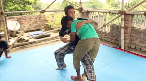 Boy practices a take-down on another while practicing jiu jitsu wrestling Stock Footage 58458688