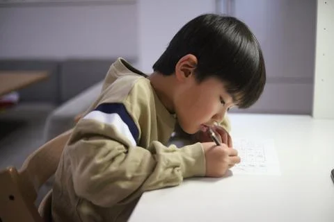 A boy practicing hard penmanship Stock Photos