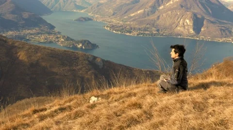 Boy practicing meditation in the mountains at sunset Stock Footage 59583175