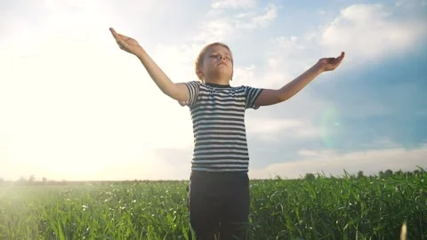 Boy prays pulls hands to the sky against a blue sky. child concept faith Stock Footage 133458800