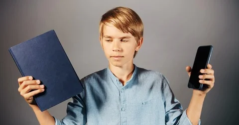 Boy Preferring Book to Smartphone Видео 115328830