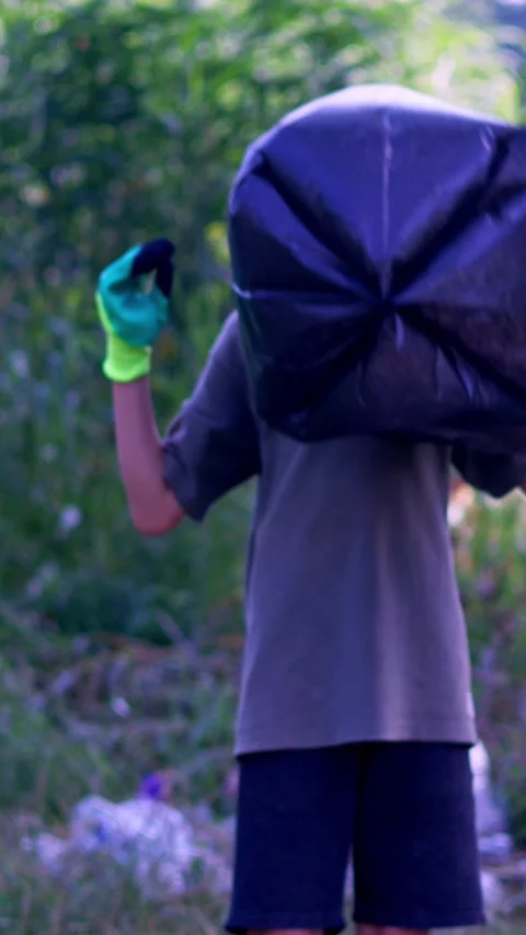 A boy prepares a bag to collect plastic waste Stock Footage 340577503