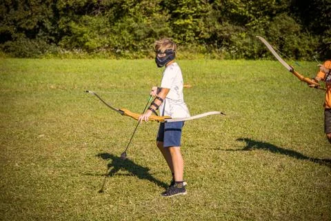 Boy preparing for an attack while playing archery tag Stock Photos
