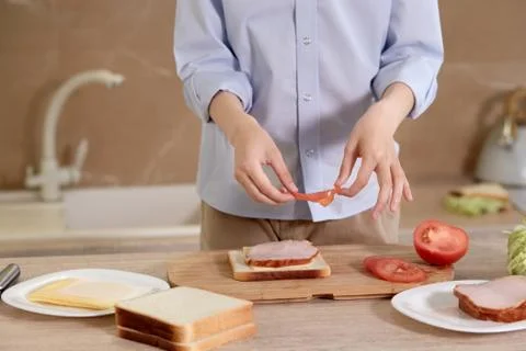 Boy is preparing breakfast for himself. Child is preparing a sandwich of bread. Stock Photos