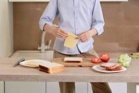 Boy is preparing breakfast for himself. Child is preparing a sandwich of bread. Stock-Fotos