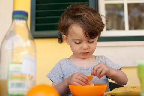 A boy preparing to eat a slice of fresh orange for breakfast Stock Photos