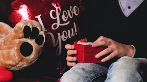 Boy preparing to give his beloved girl Valentines Day box, balloon and teddy bea Stock Footage 146913984