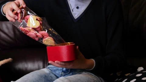 Boy preparing heart box gift with sweets cakes to beloved girl Stock Footage 146914074