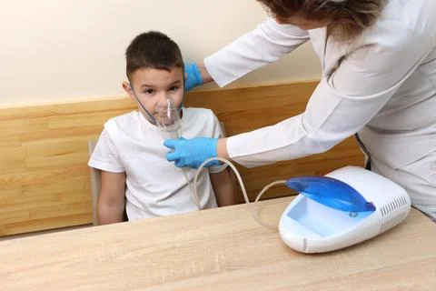 The boy is preparing for the nebulizer inhalation procedure. Stock Photos